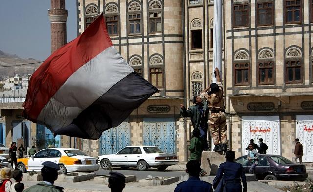 Members of the Yemeni air force raise the flag