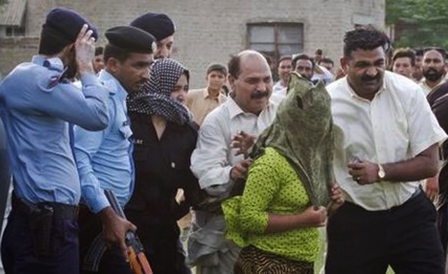 armed police surrounding Rimsha Masih covering her face with a green scarf Photo courtesy AP